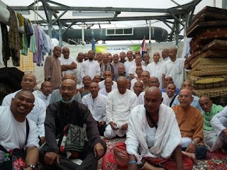 Jemaah lelaki yang telah bercukur kepala duduk bersama di khemah Mina