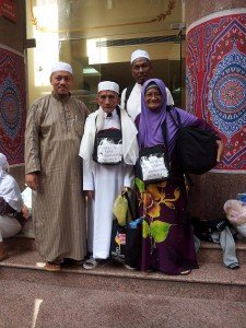 Seorang jemaah warga emas bersama dua ahli rombongan di lobi hotel