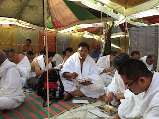 Jemaah haji bermunajat sambil membaca buku doa di bawah khemah Arafah